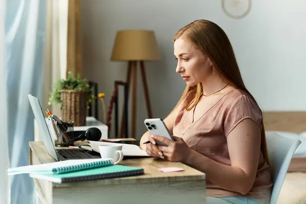 Una giovane donna gode di un'atmosfera accogliente a casa, concentrata sul suo telefono mentre circondata da decorazioni calme. — Foto stock