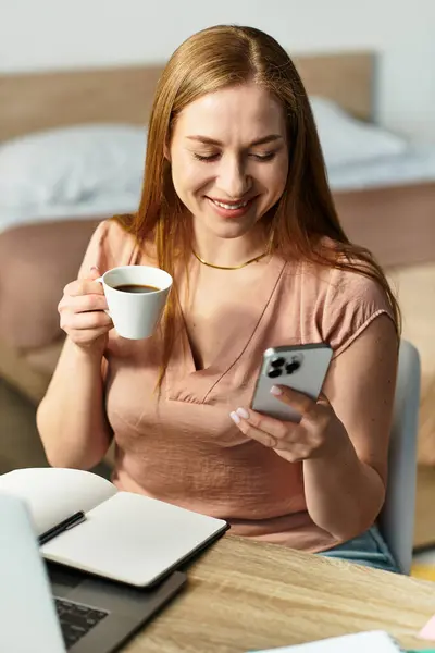 Woman relaxes with a cup of coffee while browsing her phone in a cozy home setting. — Stock Photo