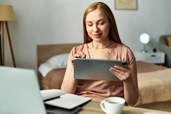 In a warm and inviting room, a young woman engages with her tablet, savoring a peaceful moment. — Stock Photo