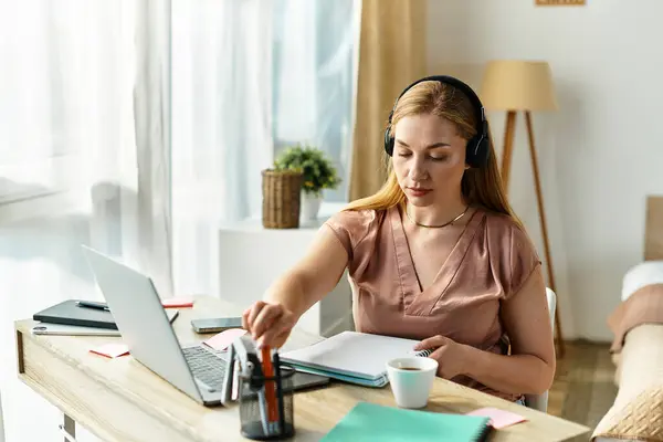 A beautiful young woman immerses herself in work at home, creating a cozy and focused environment. — Stock Photo