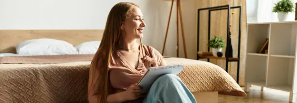 A beautiful woman sits comfortably in her cozy home, sketching ideas while savoring solitude. — Stock Photo