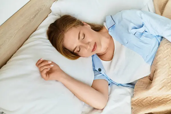 Eine junge Frau schlummert friedlich in ihrem gemütlichen Schlafzimmer und strahlt Ruhe und Komfort aus. — Stockfoto
