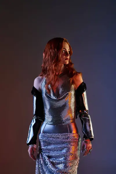 Eine junge Frau trägt selbstbewusst ein schickes metallisches Outfit, das Eleganz in sanftem Licht ausstrahlt. — Stockfoto