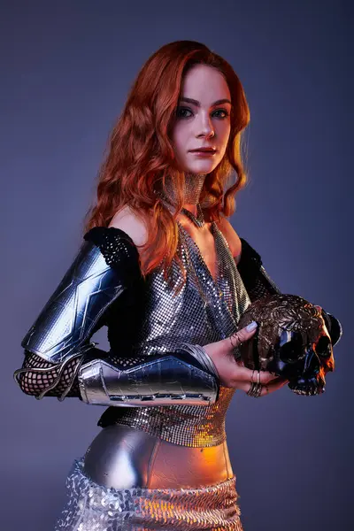 A young woman in stunning armor holds an ornate skull in a castle themed setting. — Stock Photo