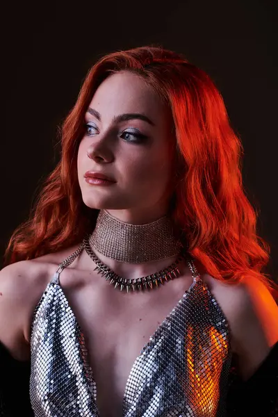 A young woman in stunning silver fashion embodies elegance, captivating with her confident gaze. — Stock Photo