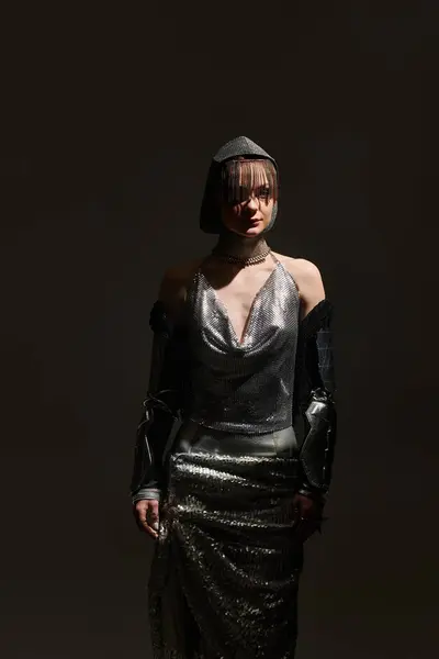 A beautiful woman stands confidently in an eye catching metallic ensemble, embracing a unique style. — Stock Photo