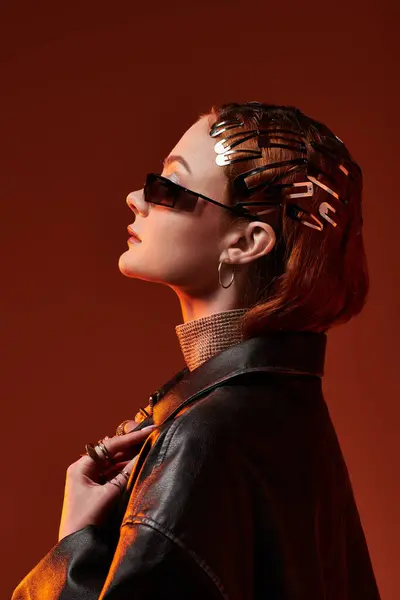 A young, beautiful woman showcases elegant fashion with unique accessories against a warm backdrop. — Stock Photo