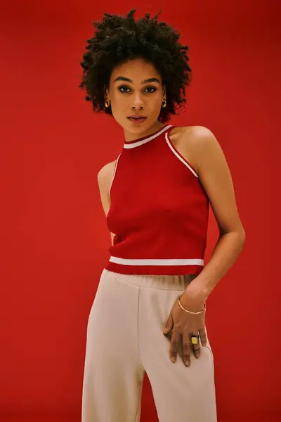 A young beautiful woman poses confidently in a stylish outfit, radiating fashion and creativity. — Stock Photo