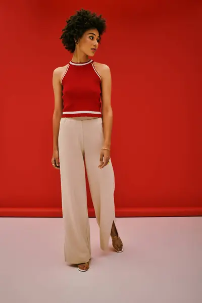Beautiful young woman stands gracefully in stylish outfit, radiating confidence and elegance. — Stock Photo