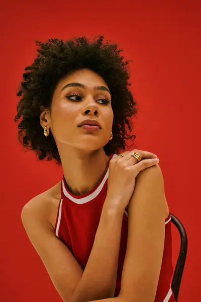 Una hermosa joven con rizos naturales muestra su sentido de la moda y su estilo único. - foto de stock