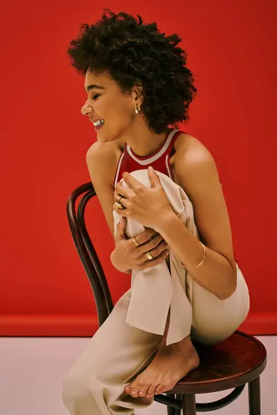 A joyful young woman with curly hair captures the essence of confidence in a vibrant setting. — Stock Photo