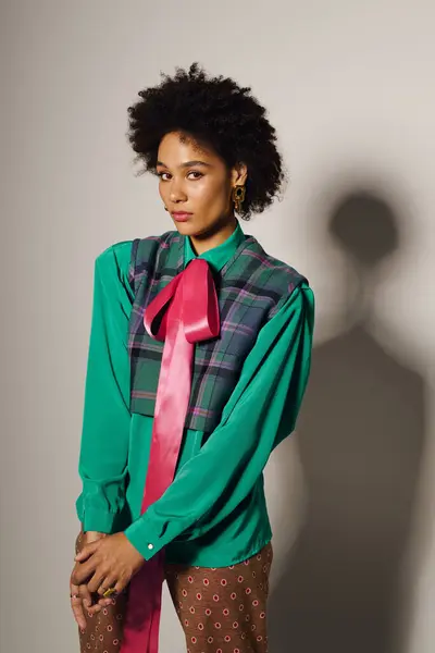 Confident young woman poses indoors in a vibrant outfit with bold accessories. — Stock Photo