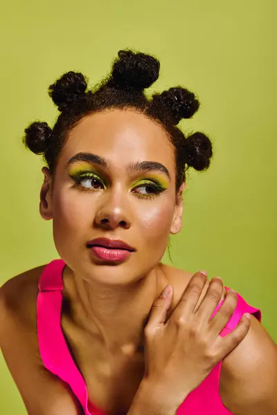 Young woman with unique hairstyle and colorful makeup showcases modern fashion in studio. — Stock Photo