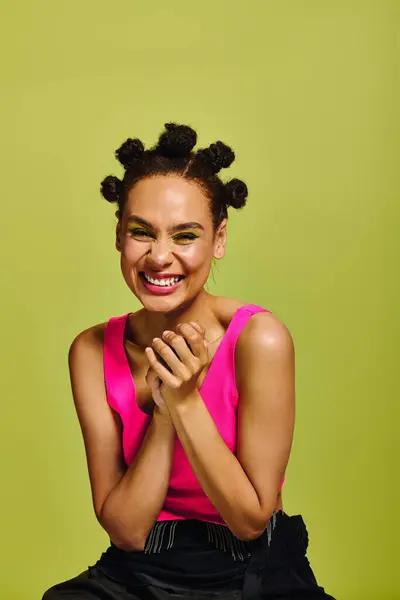Mulher jovem brilhantemente vestida com um penteado brincalhão irradia alegria ao se envolver com a câmera. — Fotografia de Stock