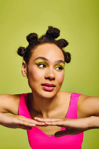 Young woman poses confidently, showcasing her unique hairstyle and bold makeup in the sun. — Stock Photo