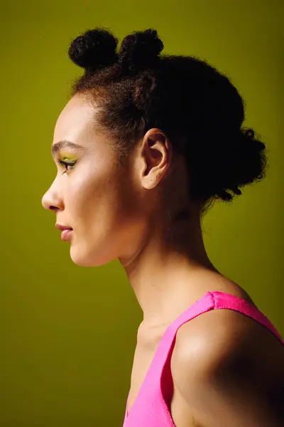 A lovely young woman poses elegantly, highlighting her stylish outfit and artistic hairstyle. — Stock Photo