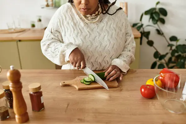 Uma jovem afro-americana habilmente prepara uma salada vibrante em sua cozinha acolhedora. — Fotografia de Stock