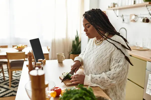 In una cucina luminosa e invitante, una giovane donna trita abilmente le verdure mentre prepara un'insalata. — Foto stock