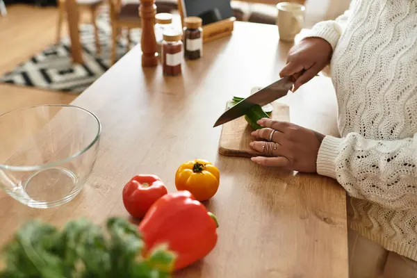 Young woman chops colorful veggies at home, making a healthy meal with fresh ingredients. — Stock Photo