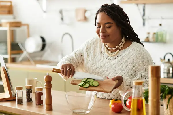 Uma jovem afro-americana habilidosamente chops legumes frescos para uma salada nutritiva em casa. — Fotografia de Stock