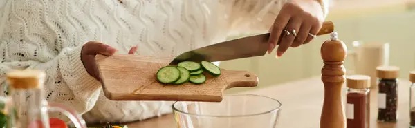 A young Black woman slices fresh cucumbers to make a salad at home, banner — Stock Photo