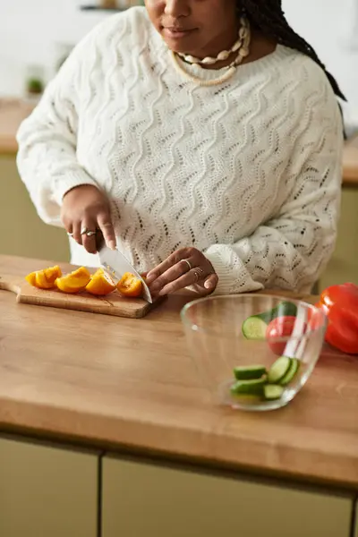 Jovem prepara uma salada vibrante usando ingredientes frescos em casa. — Fotografia de Stock