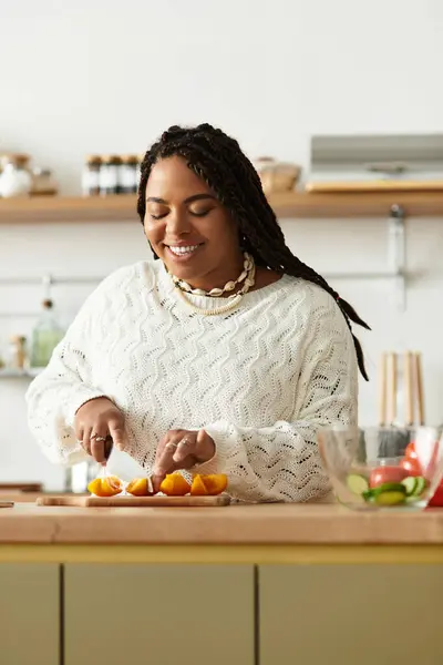 A young African American woman prepares a vibrant salad at her cozy home kitchen, smiling joyfully. — Stock Photo