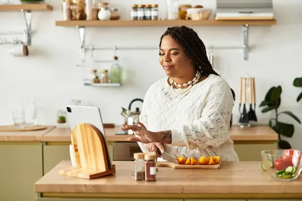 Young woman prepares a colorful salad while enjoying her time in a warm kitchen. — Stock Photo
