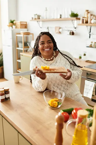 Smiling young woman prepares fresh salad ingredients in a bright and inviting kitchen space. — Stock Photo