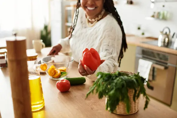 Uma jovem negra faz alegremente uma salada vibrante em casa, saboreando o processo de cozimento. — Fotografia de Stock