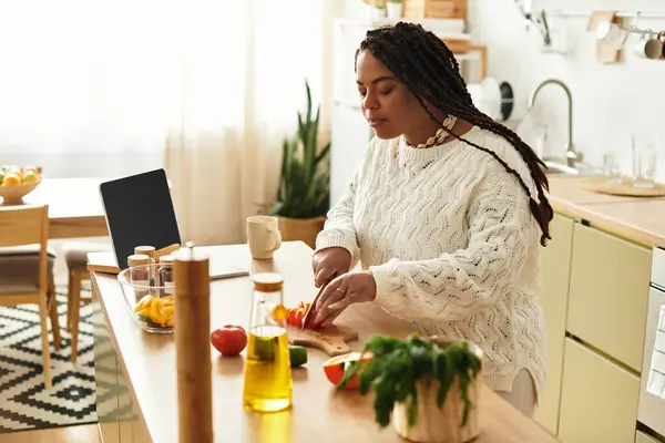 Young African American woman skillfully prepares a vibrant salad, embracing the joy of cooking. — Stock Photo