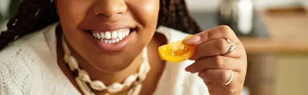 A young african american woman holding organic tomato slice at her cozy home, banner — Stock Photo