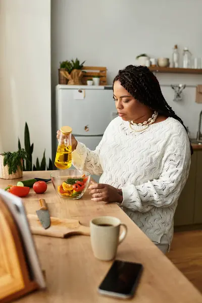 Jovem afro-americana prepara uma salada colorida com ingredientes frescos e azeite. — Fotografia de Stock