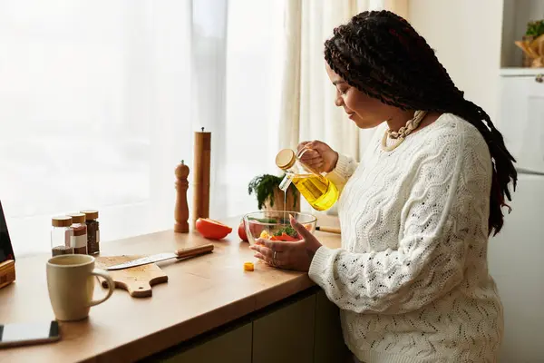 A young Black woman enjoys making a healthy salad with colorful ingredients. — Stock Photo