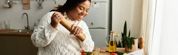 Giovane donna afroamericana gode di cucinare un'insalata fresca a casa, piena di felicità, striscione — Foto stock