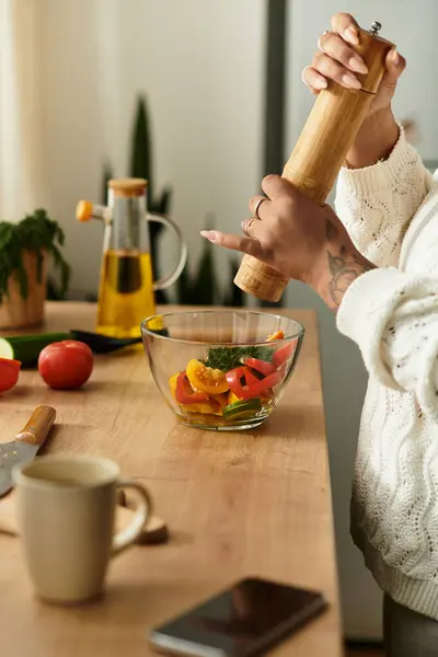 Uma jovem mulher mede cuidadosamente uma salada vibrante em uma cozinha acolhedora, cheia de luz. — Fotografia de Stock