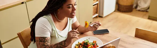 Jovem se entrega a uma deliciosa salada em casa, abraçando hábitos alimentares saudáveis. — Fotografia de Stock