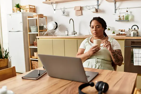 A young African American woman works diligently from her home office, sipping coffee and focused. — Stock Photo