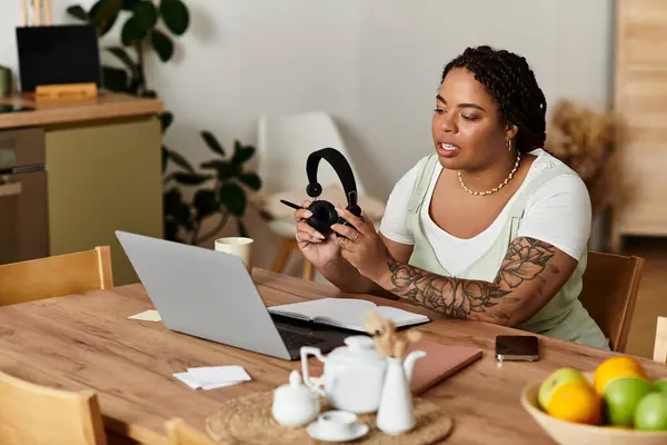 Focused young woman utilizes a laptop while working remotely in her inviting living space. — Stock Photo
