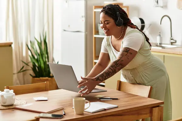 Una giovane donna afroamericana vibrante lavora sul suo computer portatile in un ambiente accogliente casa. — Foto stock