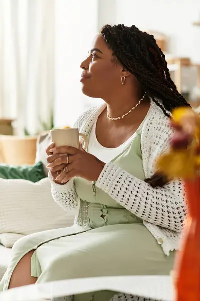 Cette jeune femme profite d'une matinée paisible à la maison avec sa boisson chaude, embrassant la tranquillité. — Photo de stock
