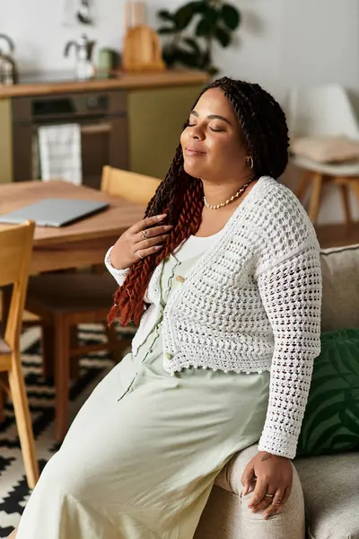 Une jeune afro-américaine se détend à la maison, profitant paisiblement de sa routine matinale tranquille. — Photo de stock
