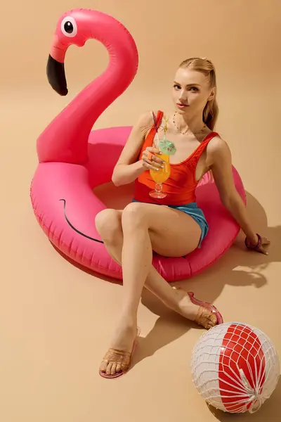 Bright, playful atmosphere as a beautiful woman relaxes in summer attire on a flamingo float. — Stock Photo