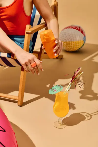 Young woman in bright beachwear enjoys a refreshing cocktail in the sun. — Stock Photo