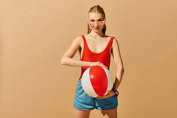 Brightly dressed young woman enjoys a playful moment holding a beach ball, radiating fun and style. — Stock Photo