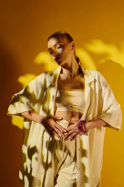 Une jeune femme modèle des vêtements élégants, avec des ombres ludiques sur un fond lumineux. — Photo de stock