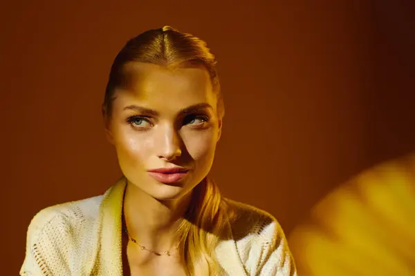 Beautiful young woman poses gracefully, illuminated by warm golden tones, radiating elegance. — Stock Photo