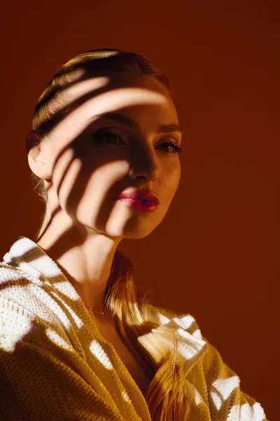 Jeune belle femme pose gracieusement, modèles d'ombre mettant en valeur ses caractéristiques captivantes. — Photo de stock