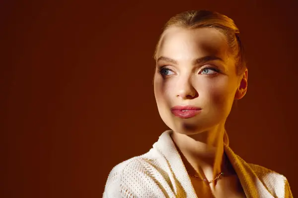 Elegant young woman gazes thoughtfully as soft light highlights her striking appearance and beauty. — Stock Photo