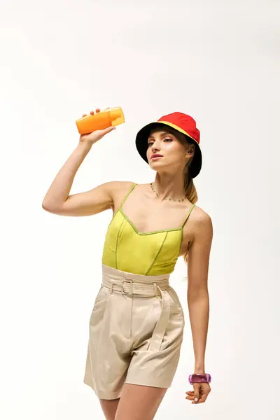 Confident woman in bright attire holds a drink, embodying summer vibes and playful fashion choices. — Stock Photo